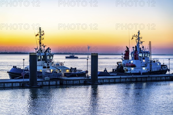 The tugboat pier, harbour tugs waiting for their next assignment, at the New Harbour, sunset over the Weser estuary with in Bremerhaven, Bremen, Germany, Europe
