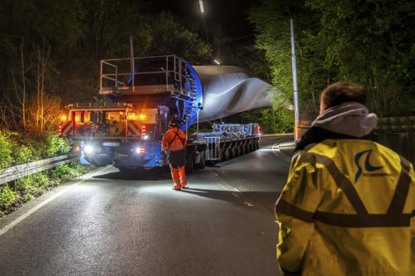 Transport of a 68 metre long, 22 tonne blade of a wind turbine, here in Schwelm, with a self-propelled Blade-Lifter vehicle, over a 40 km long route, over 2 nights, in the Bergisches Land, through towns, villages, over country roads, narrow through roads, to the construction site of the wind turbine near Hagen, North Rhine-Westphalia, Germany, Europe