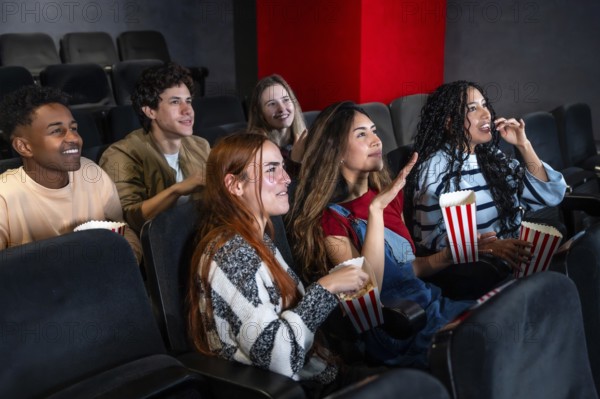 Friends enjoying a film in a movie theater, munching on popcorn and sharing laughter, creating joyful memories together