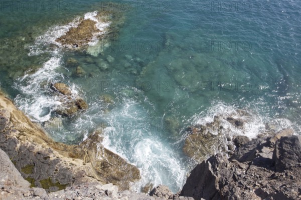 Rocky coast with blue, undulating sea water on a cliff, Playa Blanca, Lanzarote, Canary Islands