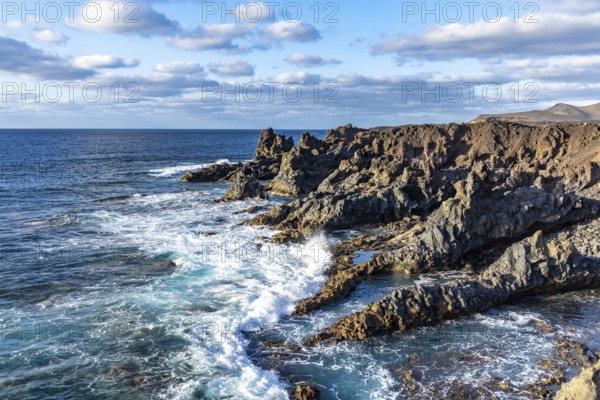 Rocky coast with crashing waves and blue sky, Canary Islands, Lanzarote, Spain, Europe