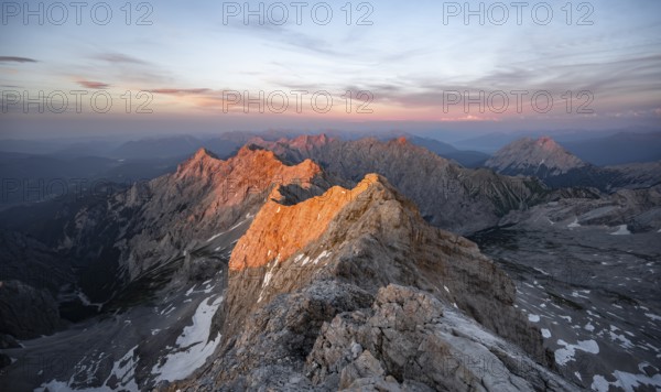 Impressive rocky mountain landscape, steep mountain ridge, Jubiläumsgrat with Alpspitze, mountain panorama from the summit of the Zugspitze, alpenglow at sunset, Northern Limestone Alps, Wetterstein Mountains, Bavaria, Germany, Europe