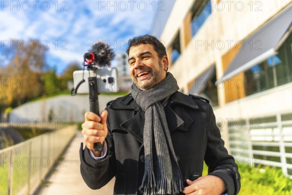 Mature elegant man vlogger smile while recording videoblog content in the city