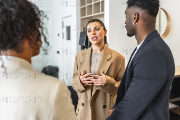 Businesswoman gesturing while speaking to her colleagues during a team meeting in a modern office environment
