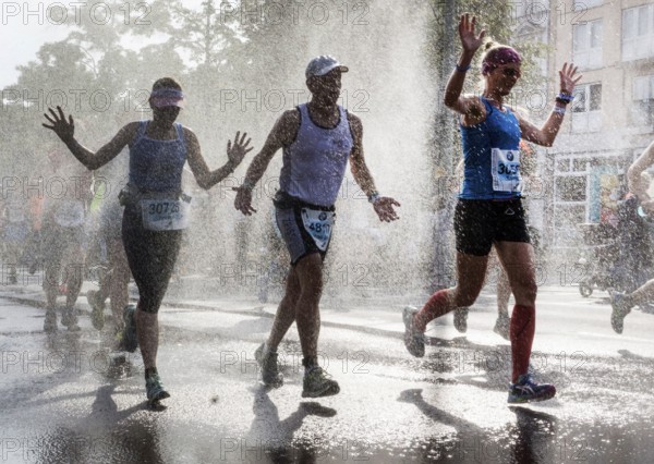 The participants of the Berlin Marathon are cooled down with a water shower in the Schöneberg district of Berlin, 25/09/2016