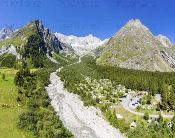 Panoramic aerial view of a campsite at a glacial river, mountain range with glacies in the back, La Fouly, Switzerland, Europe