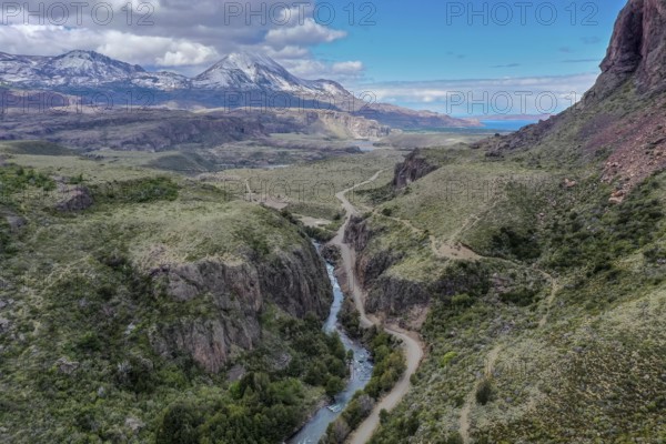 Canyon of river Rio Claro, gravel road along the river, view towards mountain range at Puerto Ingeniero Ibanez, Patagonia, Chile, South America
