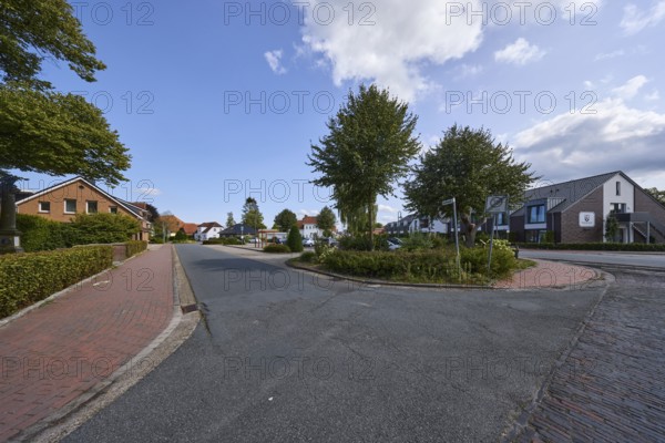 Residential area, residential building, trees, blue sky with fair weather clouds, intersection Westerende with Dammstraße and Bohlenberger Straße, Zetel, district Friesland, Lower Saxony, Germany, Europe