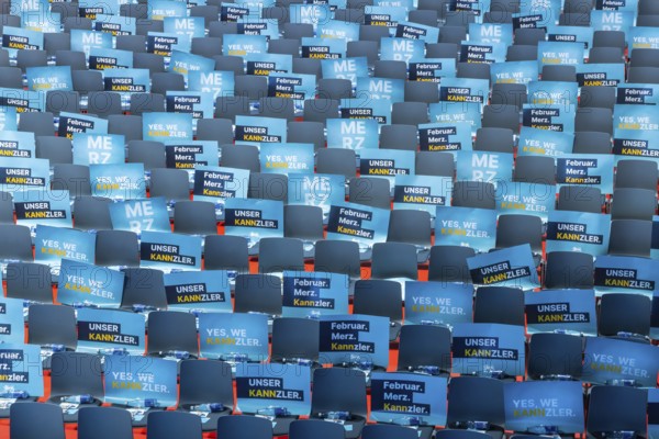 Assembly hall, deserted with many empty chairs and posters with the inscription UNSER KANNZLER. Bundestag election campaign of the CDU party for the party's candidate for chancellor Friedrich Merz, symbolic photo. Election rally in Künzelsau, Baden-Württemberg, Germany, Europe