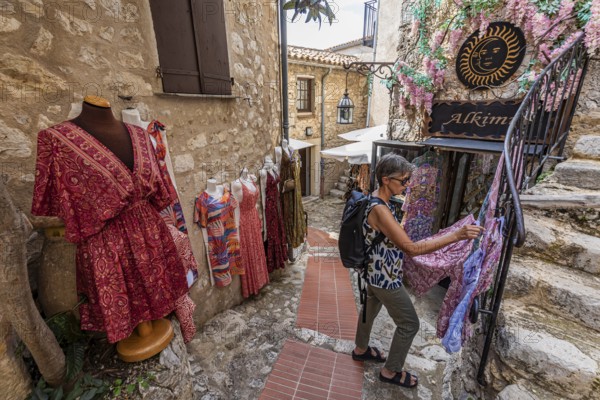 Women's clothing, woman, 62 y., in front of Boutique Alkimia in the mountain village Èze Village on the Côte d'Azur, Provence-Alpes-Côte d'Azur, France, Europe