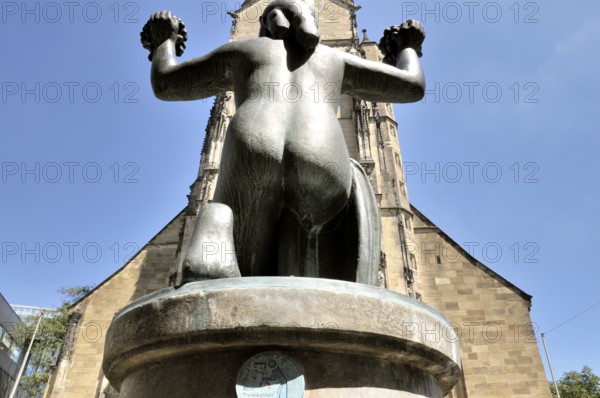 The collegiate church is the oldest Protestant church in Stuttgart and one of the city's landmarks. The female figure on the fountain holds two grape vines in her hands as a gesture of harvest blessing and thanksgiving, Stuttgart, Baden-Württemberg, Germany, Europe