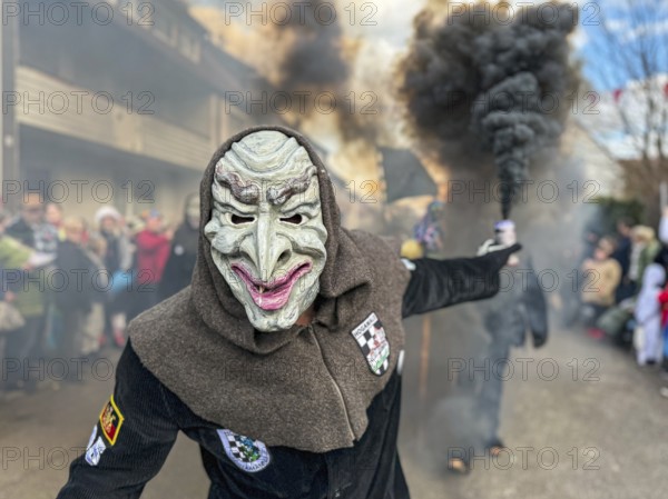 Portrait of Hofener Hogamale with smoke bomb at the big carnival parade of the Hofener Scillamännle, Hofen, Stuttgart, Baden-Württemberg, Germany, Europe