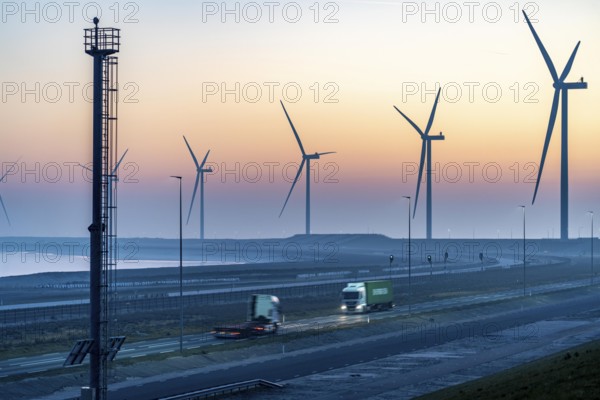 Lorry on the road to Euromax Terminal Rotterdam, ENECO wind farm on the dike around the port of Maasvlakte 2, 22 wind turbines with a capacity of 116 megawatts, sunset, Rotterdam, Netherlands