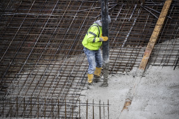 Construction site, concreting, the foundation of a building is concreted, the concrete is pumped onto the reinforced concrete mats