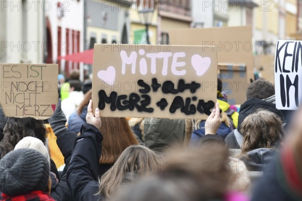 Heidelberg, Germany - February 12th 2025: Person holding up sign saying 'Middle insteaf of Merz and Alice' in crowd at protest against far-right