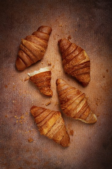 Fresh croissants, breakfast, top view, on the table, brown background, no people