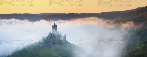 View of the Reichsburg Cochem with morning mist in the Moselle valley, Cochem, Rhineland-Palatinate, Germany, Europe
