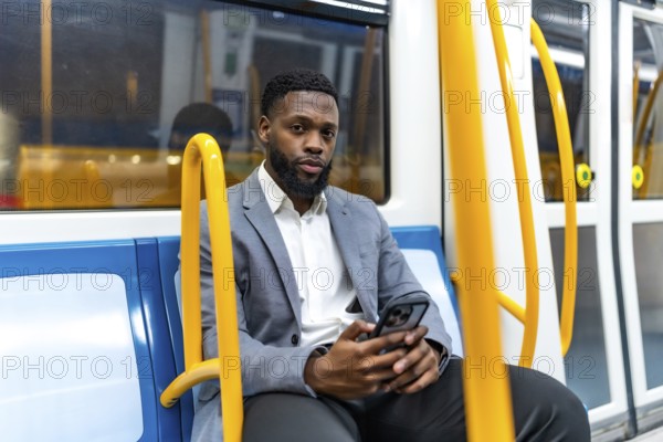 Young businessman sitting on a subway train, using a smartphone during his daily commute, staying connected in the urban environment