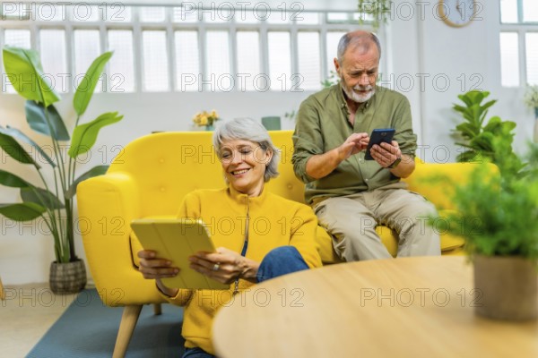 Senior couple using diverse devices and technology together at home