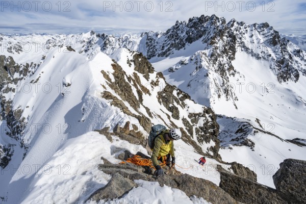 Mountaineer belaying on a steep snow slope, belaying on a rope, ascent to the summit of Piz Grialetsch in winter, view of mountain panorama with snow, Grisons Haute Route, Albula Alps, Rhaetian Alps, Grisons, Switzerland, Europe