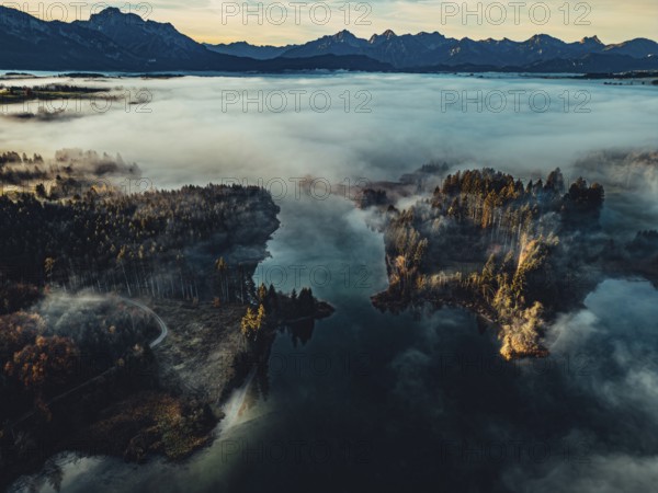 Autumn sunrise in the foothills of the Alps with fog at Illasbergsee and Forggensee near Halblech in Allgäu, Bavaria, Germany, Europe