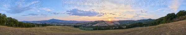 Typical Tuscan landscape in Val d'Orcia with hills, trees, fields, cypresses and farm road in autumn at sunset, La Foce, Tuscany, Italy, Europe