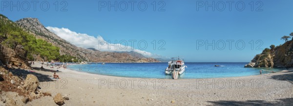 Coastal scene with a boat on Apella beach and blue sky, Apella beach, Karpathos, Greece, Europe