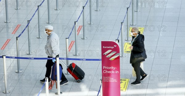 Passengers wearing face masks at the Eurowings check-in counter at Düsseldorf Airport during the coronavirus pandemic, Düsseldorf, North Rhine-Westphalia, Germany, Europe