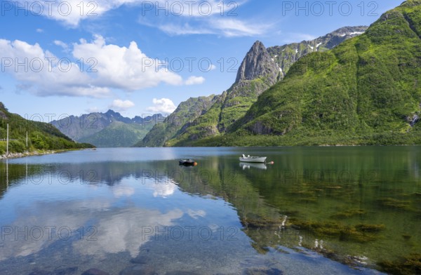 Small boats at the fjord Austnesfjorden, idyllic Norwegian fjord landscape, mountains reflected in the water, Sildpollen, Nordland, Norway, Europe