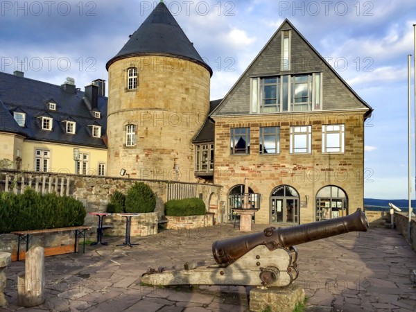 View from Altane to historical cannon in the foreground behind it on the right entrance to torture museum linka next to it castle tower of Waldeck Castle from 1120 Middle Ages 12th century, Waldeck, Hesse, Germany, Europe