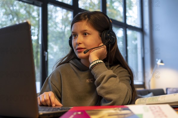 Homeschooling, girl, 11 years old, learns at home, home learning, lessons at home, distance learning, chat with teachers and classmates via laptop, symbolic image