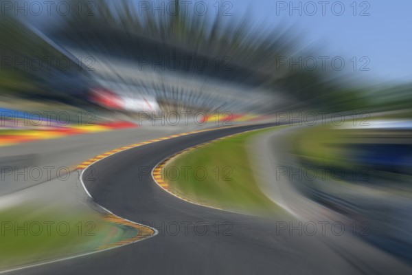 Photo of Eau Rouge with dynamic speed effect with view tunnel view from racing car perspective of racing driver while driving into dangerous curve Eau Rouge on 40 metre high driveway Raidillon of Circuit de Spa Francorchamps, in the background 2022 newly built grandstand for car racing, FIA Formula 1 race track, Circuit de Spa Francorchamps, Ardennes roller coaster, Ardennes, Malmedy, Belgium, Europe