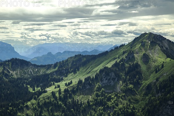 Views of green mountain slopes, forests and a cloudy sky make for impressive natural scenery in the Chiemgau mountains