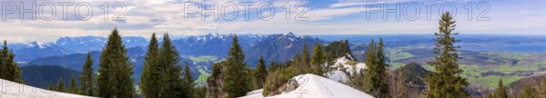 Panoramic view over the snow-covered Chiemgau mountains with forest and clear blue sky in the background Lake Chiemsee in Bavaria Germany Europe