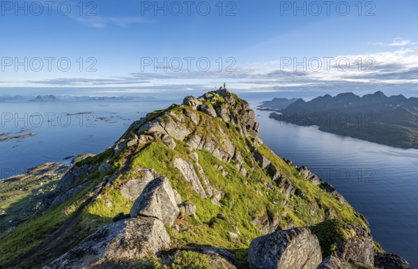 Climber on the summit of Dronningsvarden or Stortinden, behind sea and fjord Umvågsundet, Vesterålen, Norway, Europe