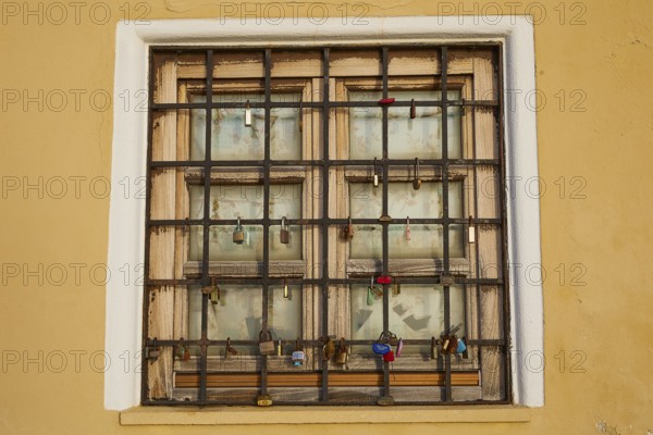 A shuttered window with bars in a yellow wall, harbour area, Rhodes Town, Rhodes, Dodecanese, Greek Islands, Greece, Europe