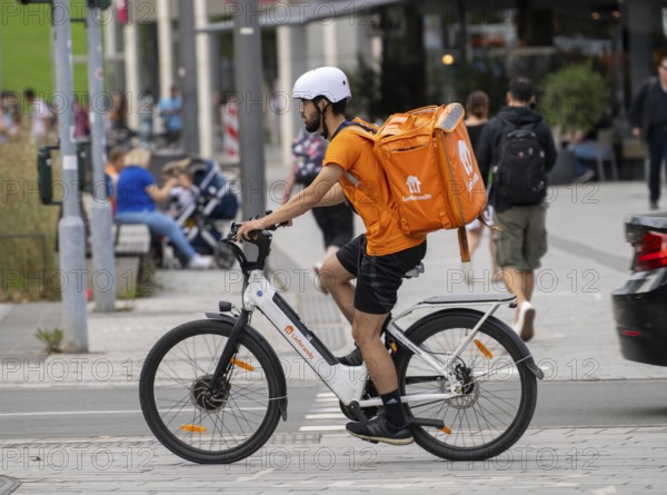 Lieferando delivery service, bicycle courier with thermal rucksack, e-bike, Düsseldorf, North Rhine-Westphalia, Germany, Europe