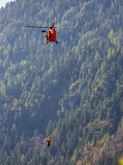 2 mountain rescuers of the Bavarian Mountain Rescue Service are winched by the on-board mechanic of the rescue helicopter Christoph 14 with the cable winch, Bad Reichenhall, Berchtesgadener Land, Upper Bavaria, Bavaria, Germany, Europe