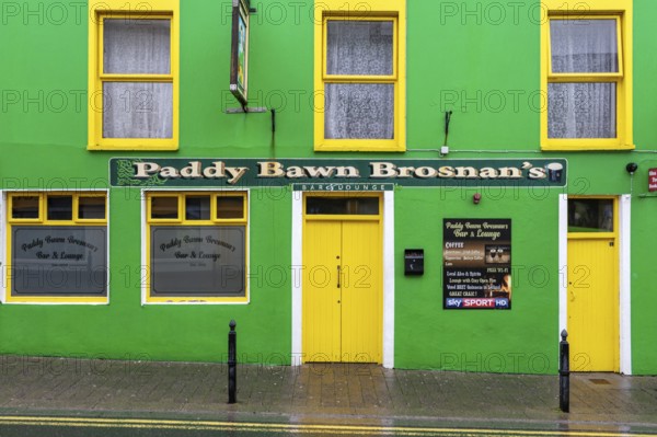 A green-painted pub façade on the roadside, Dingle