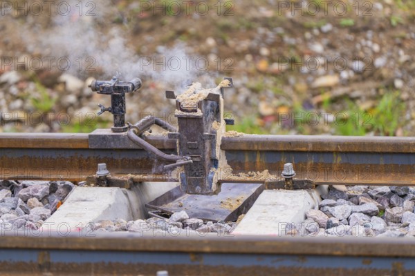 Metal fixture on the rails with rising smoke, rural environment, rail welding, track construction Hermann Hessebahn, Calw, Black Forest, Germany, Europe