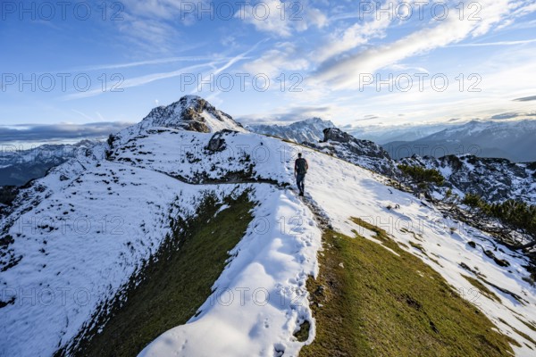 Mountaineer on hiking trail, mountain landscape with snow in autumn, summit and ridge of the Kramerspitz, Ammergau Alps, in autumn, Bavarian Alps, Bavaria, Germany, Europe