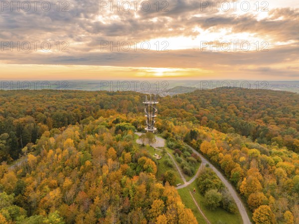 Majestic tower amidst a vibrant autumn forest under a dramatic sunset sky, Schönbuchturm, Herrenberg, Germany, Europe