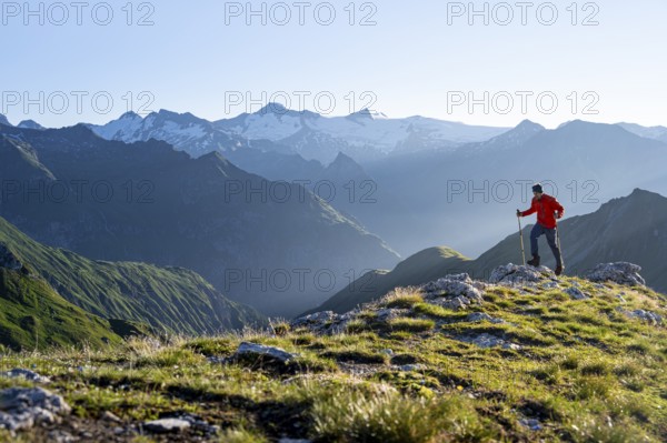Hiker enjoying the mountain panorama in the morning, Venediger group, behind Dreiherrenkopf, Simonysitze and Großer Geiger, Hohen Tauern, Austria, Europe