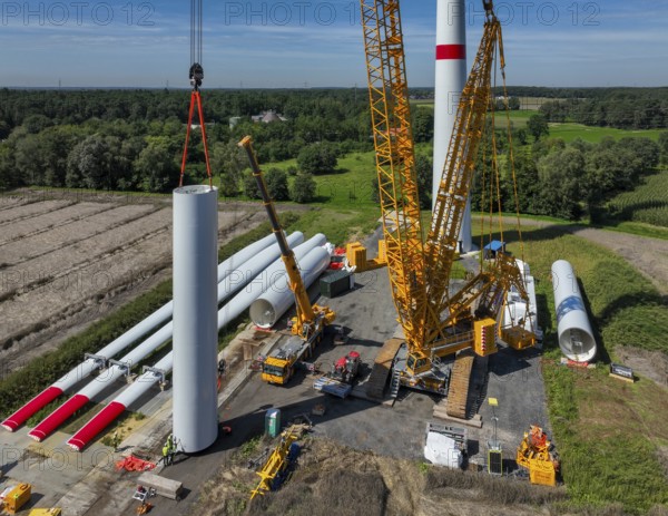 Dorsten, North Rhine-Westphalia, Germany, construction of a wind turbine, the first wind turbine of the Grosse Heide wind farm. The rotor blades are ready for assembly. A large mobile crane places the tower elements, the rings, on top of each other. This wind turbine will have a rated output of 5, 500 kW, Europe