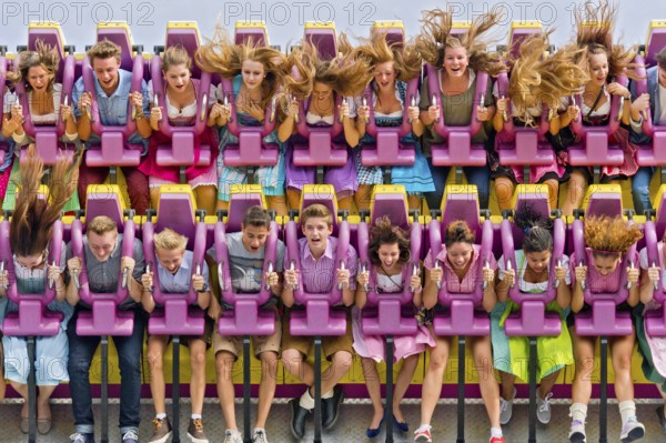 Boys and girls swinging with blowing hair in giant swing Top Spin Fresh, swing, ride on the Wies'n, Oktoberfest, Wiesn, Munich, Upper Bavaria, Bavaria, Germany, Europe