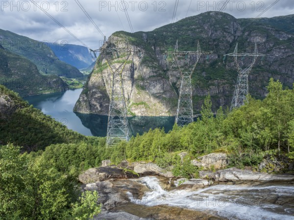 High voltage power lines above the Aurlandsfjord, a branch of the Sognefjord., transports electrical energy from multiple power station in the Aurland valley, Sognefjord region, Norway, Europe