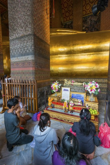The reclining Buddha with praying believers in Wat Pho temple, Buddhism, religion, world religion, sculpture, sculpture, art, statue, culture, believer, faith, peace, Asian, travel, holiday, tourism, representation, palace, tradition, traditional, decoration, decorated, house of prayer, building, attraction, landmark, gilded, gold, holy, pray, meditation, monastery, spirituality, meditate, spiritual, monument, famous, sight, philosophy, architecture, capital, Bangkok, Thailand, Asia