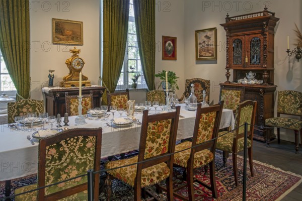 Dinner table with antique tableware in dining room inside 18th century clergy house Schriek at open air museum Bokrijk, Limburg, Flanders, Belgium, Europe