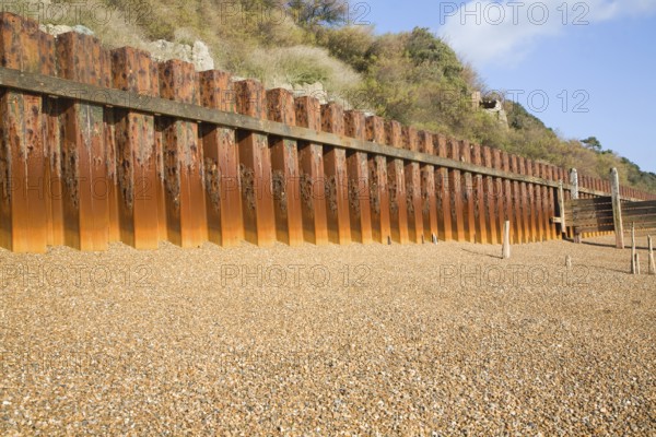 Rusty steel piling sea wall defences and shingle beach near Bawdsey Quay, Suffolk, England, United Kingdom, Europe