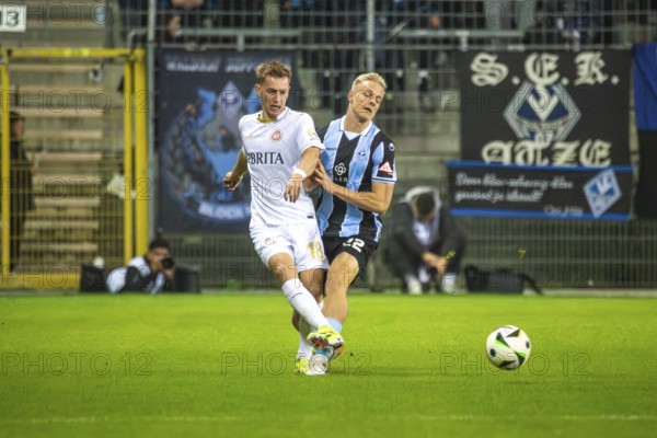 Football 3rd division, season 2024/25, matchday 12: Waldhof Mannheim vs SV Wehen-Wiesbaden. Picture: Fabian Greilinger (18, Wehen-Wiesbaden) and Janne Sietan (22, Mannheim)